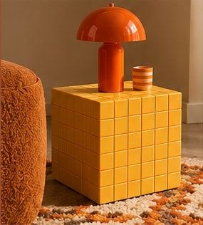 Cube carrelé jaune surmonté d’une lampe orange